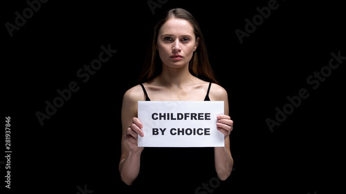 Woman showing childfree by choice sign, voluntary refusal from children, freedom photo