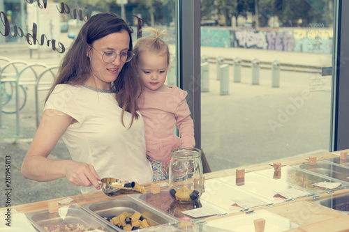 Young mother and daughter shopping in zero waste store. photo