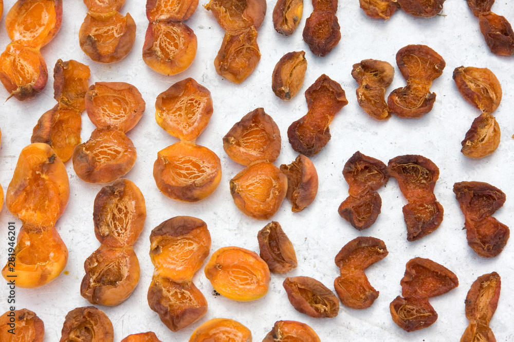 Drying apricot in the sun. Apricot halves are spread out on a metal sheet and dried in the sun. Close-up. Summer. outdoor Drying apricot in the sun. Apricot halves are spread out on a metal sheet and dried in the sun. Close-up. Summer. outdoor