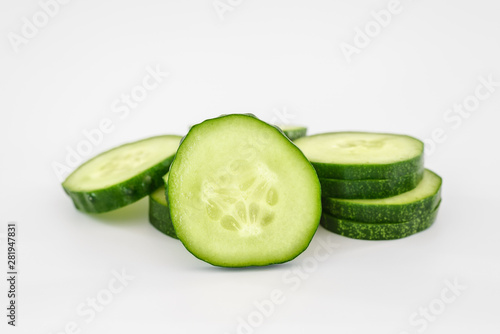 Slices of fresh juicy ripe cucumber on a uniform light white background. Minimal concept, copy space. The idea of healthy eating