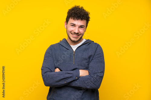 Young man over isolated yellow wall laughing