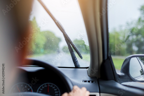 Wallpaper Mural Selective focus to man driving a car with rain droplet on windshield and wiper. Windshield wipers from inside of car, season rain. Torontodigital.ca