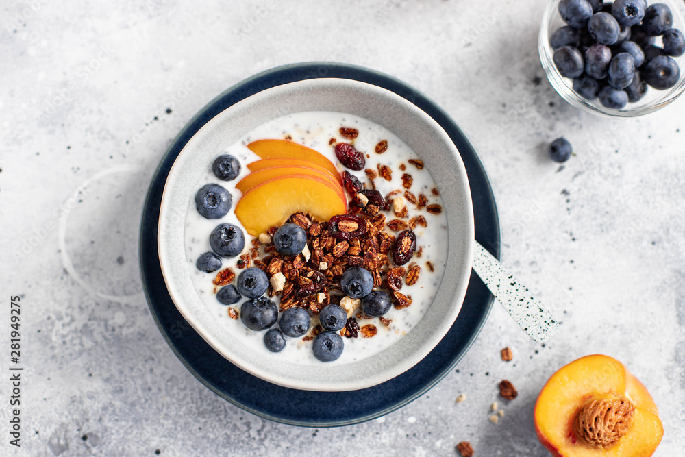 granola with yogurt, blueberries, peach and honey on a light background granola with yogurt, blueberries, peach and honey on a light background