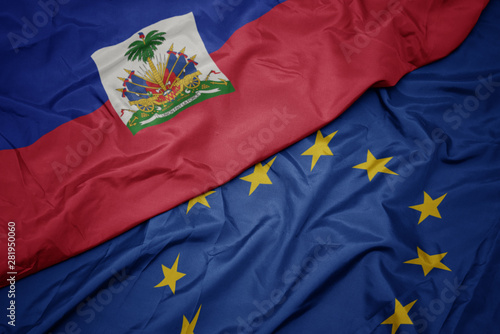 waving colorful flag of european union and flag of haiti.