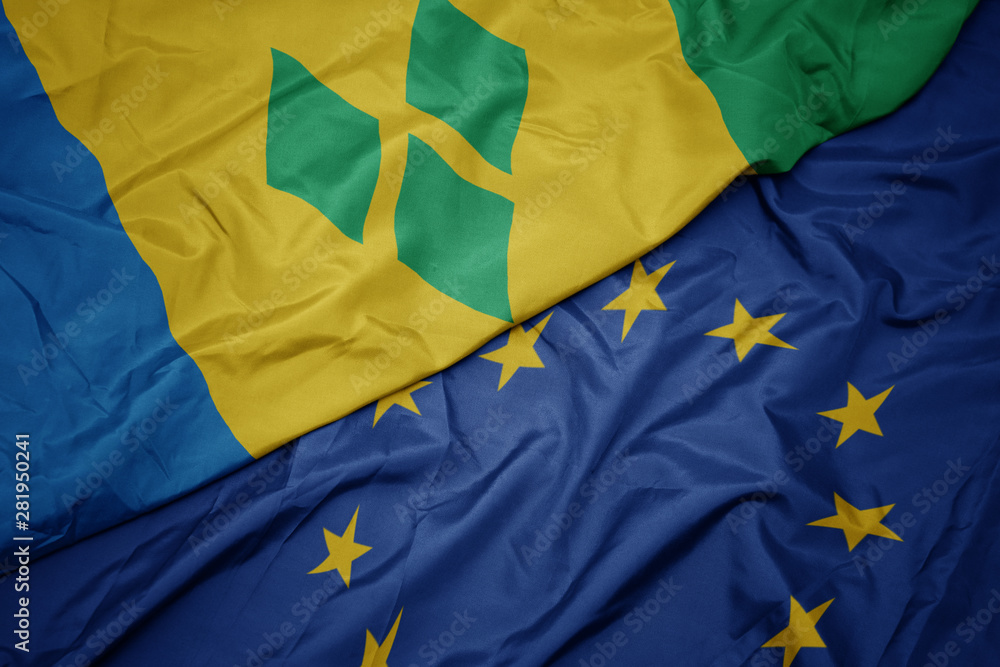 waving colorful flag of european union and flag of saint vincent and the grenadines.