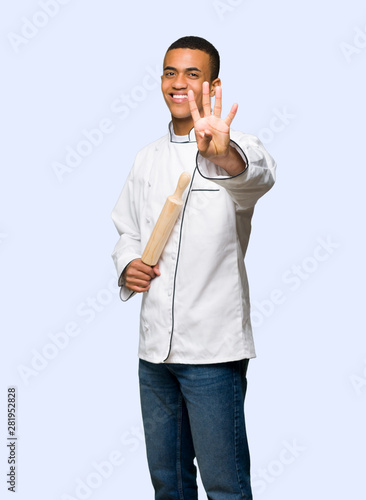 Young afro american chef man happy and counting four with fingers on isolated background