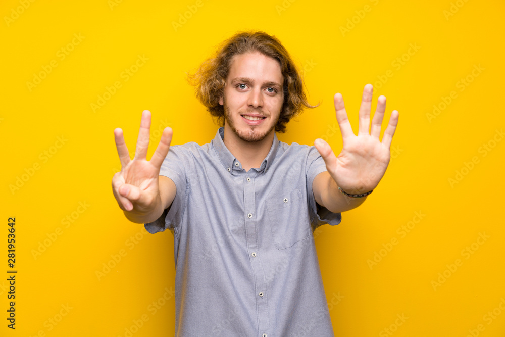Blonde man over isolated yellow background counting eight with fingers