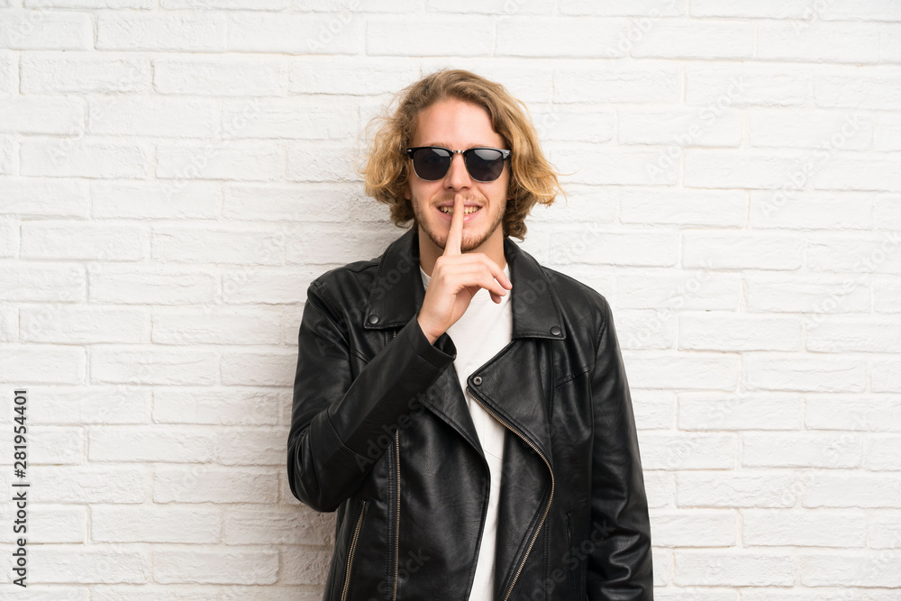 Blonde man with sunglasses doing silence gesture Blonde man with sunglasses doing silence gesture