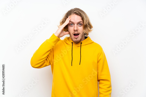 Blonde man with sweatshirt over white wall has just realized something and has intending the solution