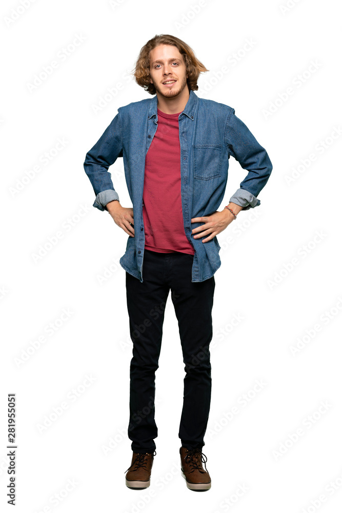 Fototapeta premium Full-length shot of Blonde man posing with arms at hip and smiling over isolated white background