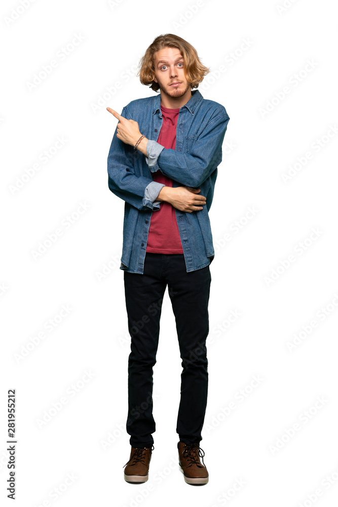 Full-length shot of Blonde man pointing to the side to present a product over isolated white background Full-length shot of Blonde man pointing to the side to present a product over isolated white background