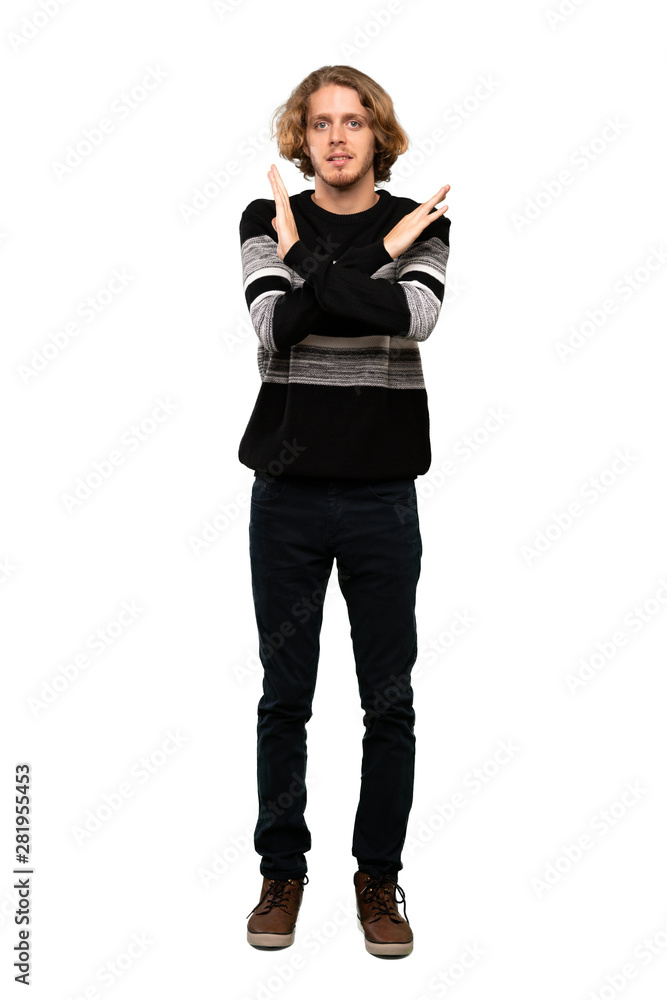 Full-length shot of Blonde man making NO gesture over isolated white background Full-length shot of Blonde man making NO gesture over isolated white background
