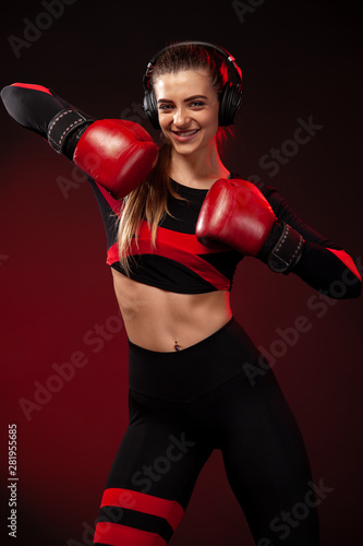 Happy and smiling young woman sportsman boxer on boxing training. Girl wearing gloves, sportswear. © Mike Orlov