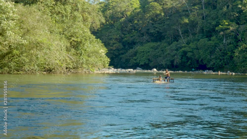 Indigenous Man Rowing Against The Current In A Wooden Raft In Ecuador Indigenous Man Rowing Against The Current In A Wooden Raft In Ecuador