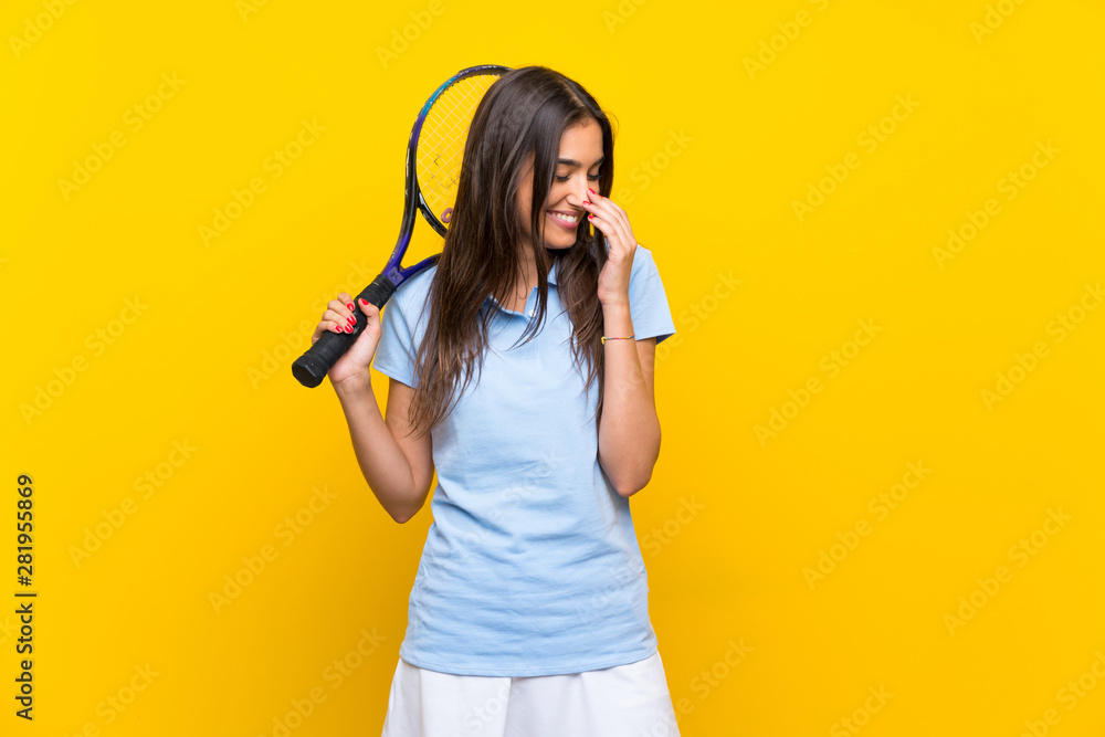 Young tennis player woman over isolated yellow wall smiling a lot Young tennis player woman over isolated yellow wall smiling a lot