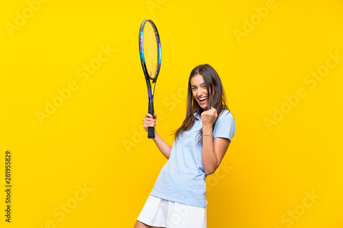 Young tennis player woman over isolated yellow wall © luismolinero