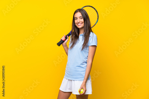 Young tennis player woman over isolated yellow wall © luismolinero