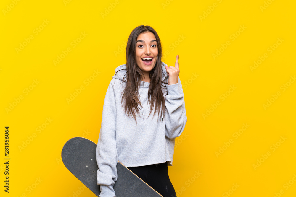 Young skater woman over isolated yellow background pointing up a great idea Young skater woman over isolated yellow background pointing up a great idea