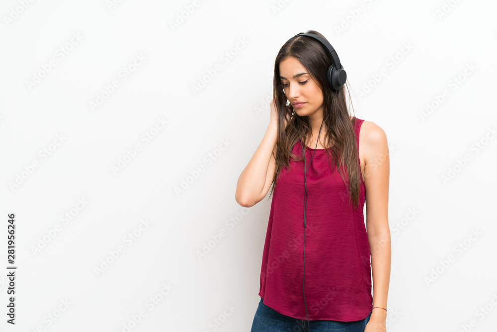 Young woman over isolated white background listening to music with headphones