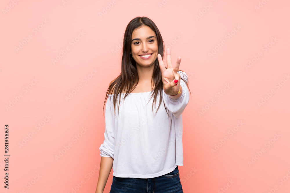 Young woman over isolated pink background happy and counting three with fingers Young woman over isolated pink background happy and counting three with fingers