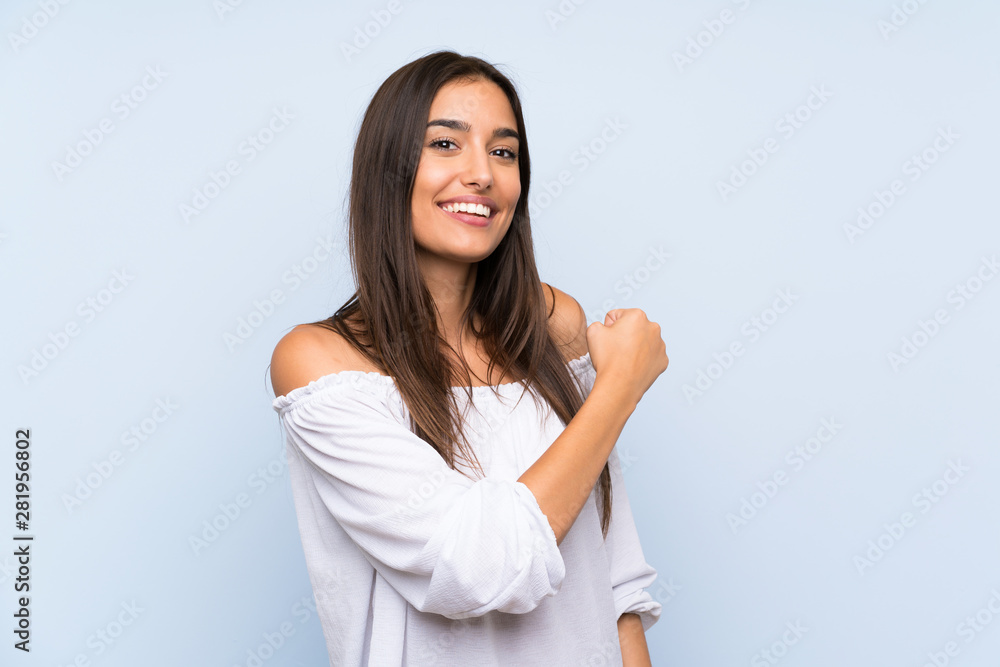 Young woman over isolated blue background celebrating a victory Young woman over isolated blue background celebrating a victory