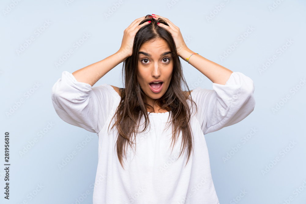 Young woman over isolated blue background with surprise facial expression
