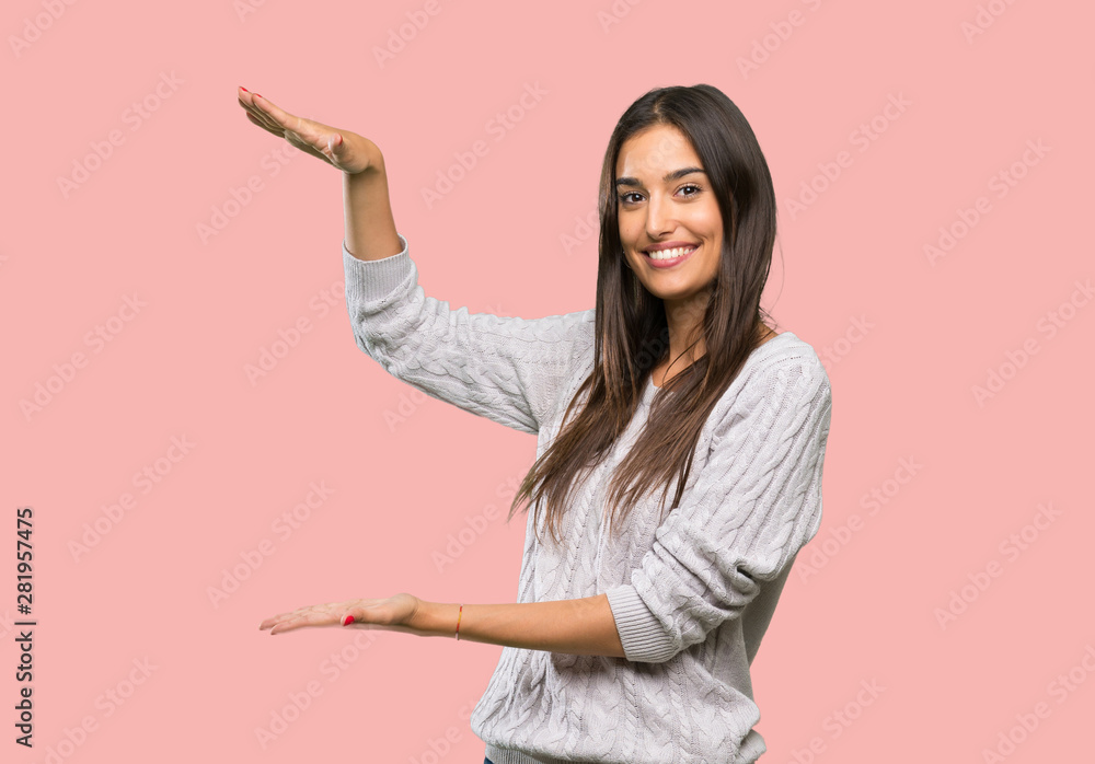 Young hispanic brunette woman holding copyspace to insert an ad over isolated background Young hispanic brunette woman holding copyspace to insert an ad over isolated background