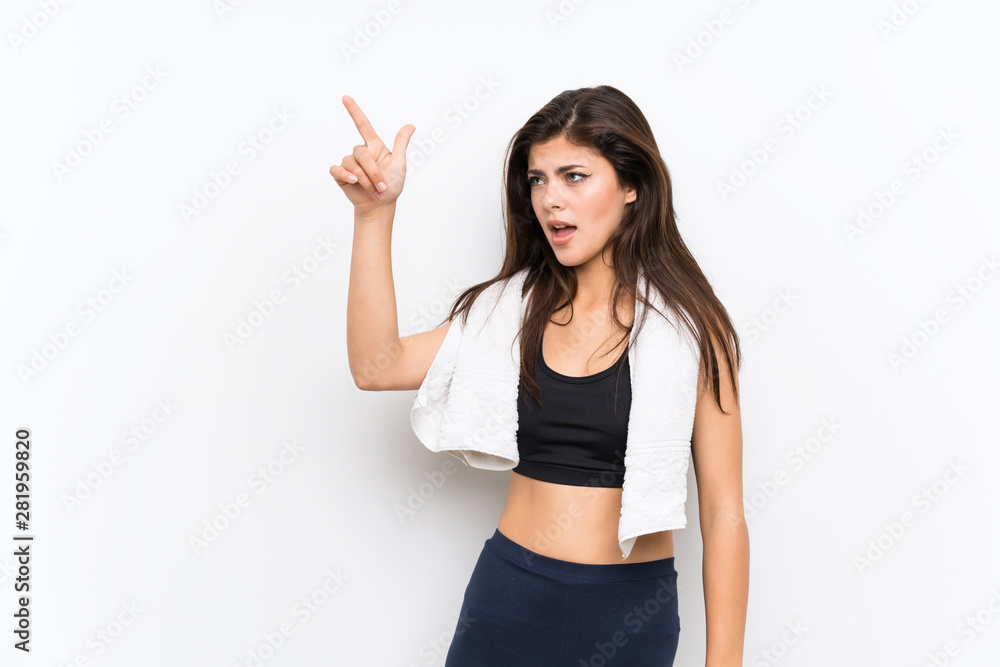 Teenager sport girl over isolated white background pointing away Teenager sport girl over isolated white background pointing away