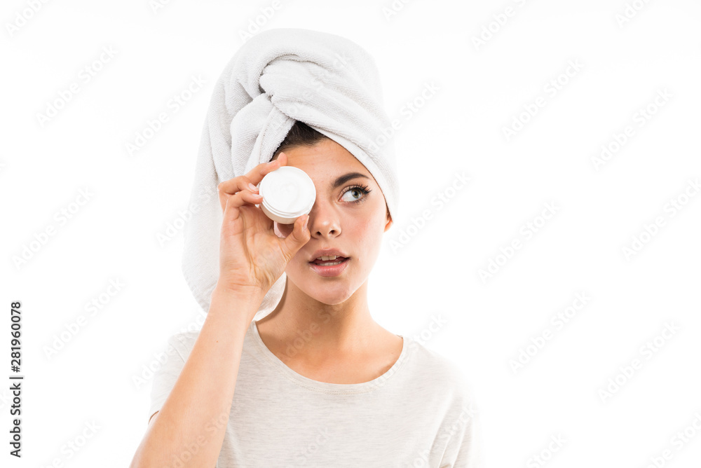 Teenager girl over isolated white background with moisturizer Teenager girl over isolated white background with moisturizer