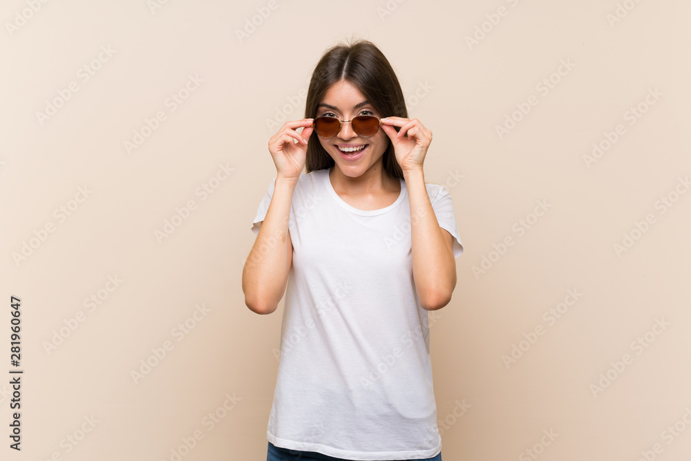 Pretty young girl over isolated background with glasses and surprised Pretty young girl over isolated background with glasses and surprised