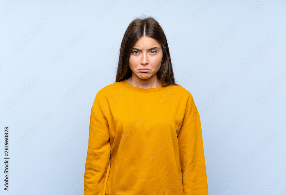 Caucasian young woman over isolated blue wall sad Caucasian young woman over isolated blue wall sad