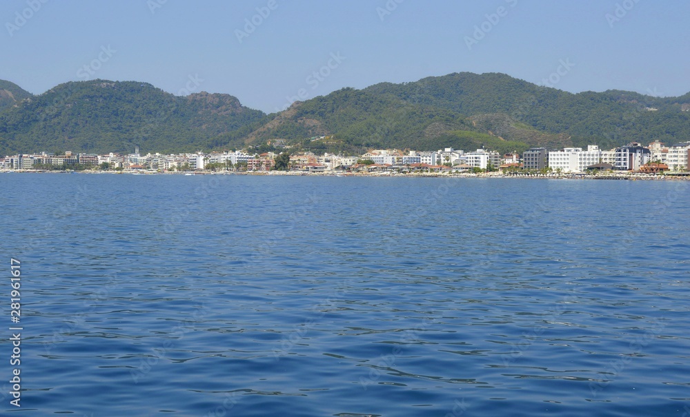 View of the embankment of the city of Marmaris from the sea. City-port and resort in Turkey. Sandy beaches, mountain landscapes.