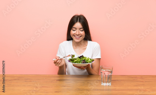 Young woman with a salad in a table