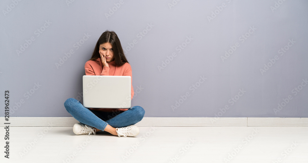 Young student girl with a laptop on the floor unhappy and frustrated Young student girl with a laptop on the floor unhappy and frustrated