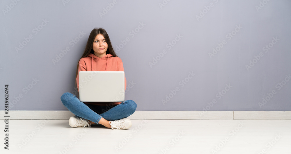 Young student girl with a laptop on the floor thinking an idea Young student girl with a laptop on the floor thinking an idea