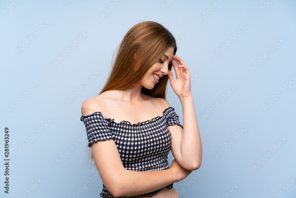 Fototapeta premium Young woman over isolated blue background laughing
