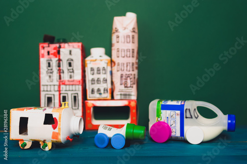 Obraz na płótnie Houses and toy cars made from milk bags. DIY paper milk bag. Creative paper milk bag ideas. Recycle crafts. w salonie