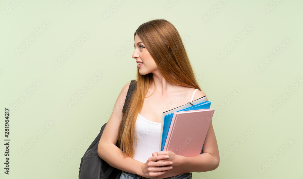 Young student woman over isolated green background looking to the side Young student woman over isolated green background looking to the side