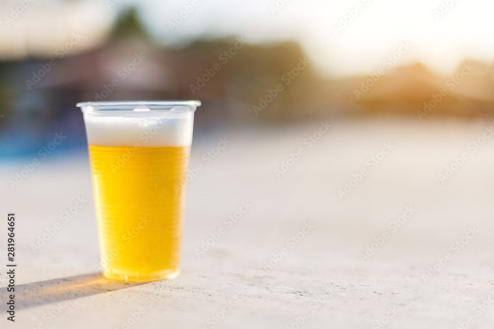 Plastic glass with cold beer. A small glass of plastic with beer in the sun. Plastic glass with cold beer. A small glass of plastic with beer in the sun.