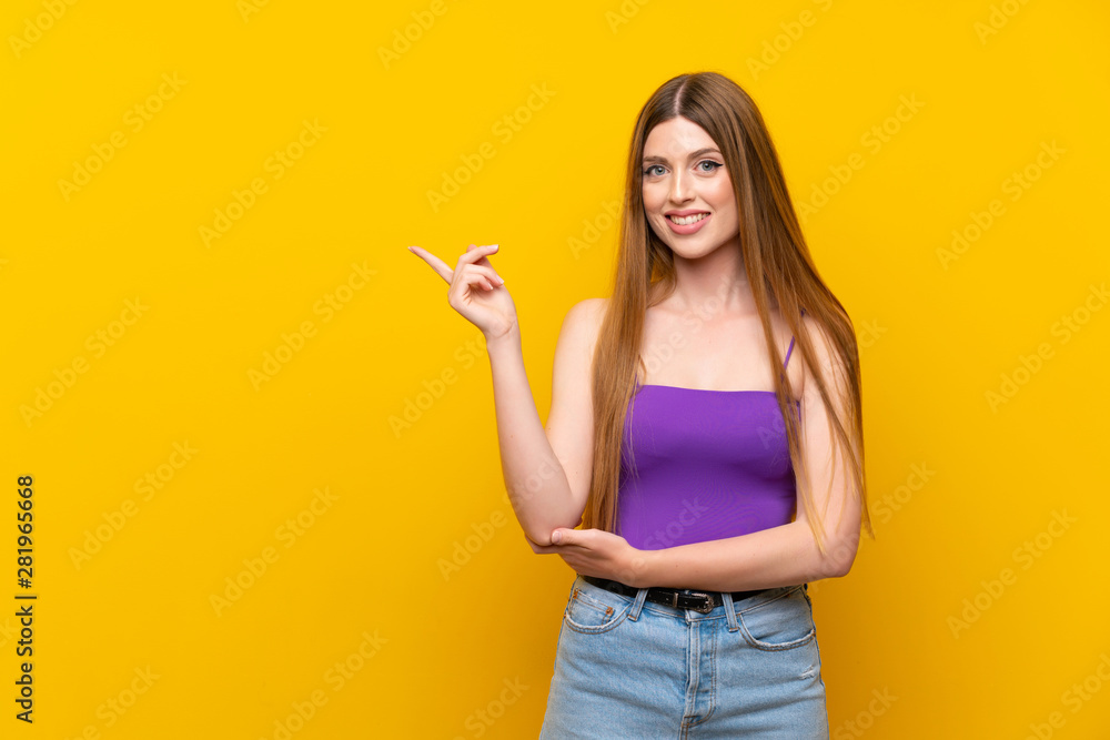 Young woman over isolated yellow background pointing finger to the side Young woman over isolated yellow background pointing finger to the side