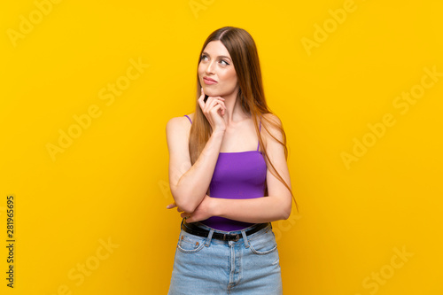 Young woman over isolated yellow background looking to the side