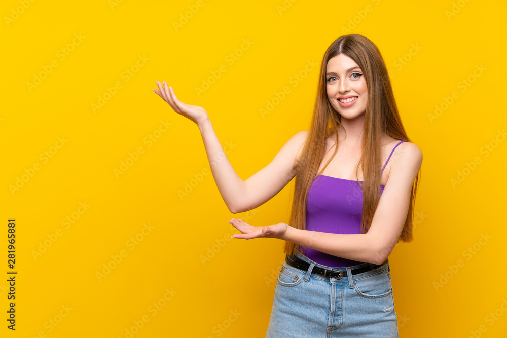 Young woman over isolated yellow background extending hands to the side for inviting to come Young woman over isolated yellow background extending hands to the side for inviting to come