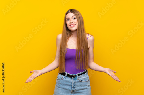 Young woman over isolated yellow background smiling