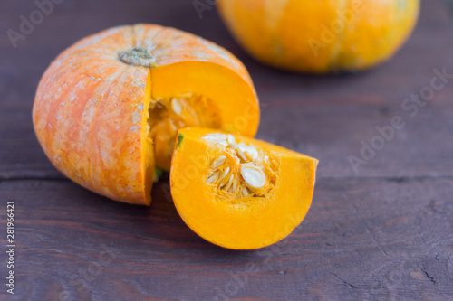 ripe fresh pumpkin cut into a wooden background,close-up
