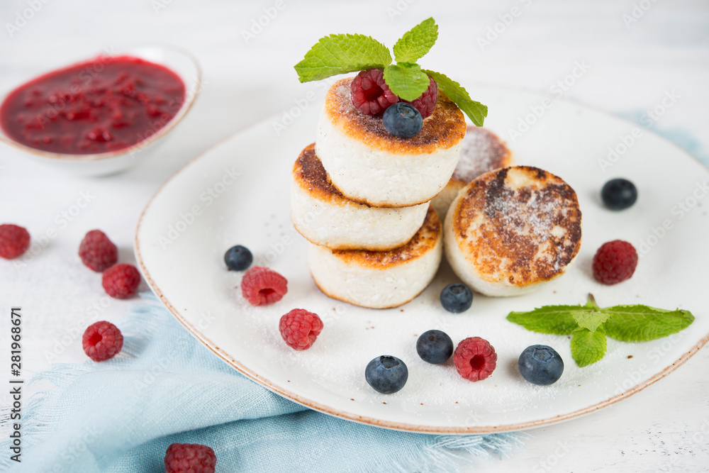 Delicious cheesecakes pancakes, decorated with fresh berries and mint. Horizontal orientation. Delicious cheesecakes pancakes, decorated with fresh berries and mint. Horizontal orientation.