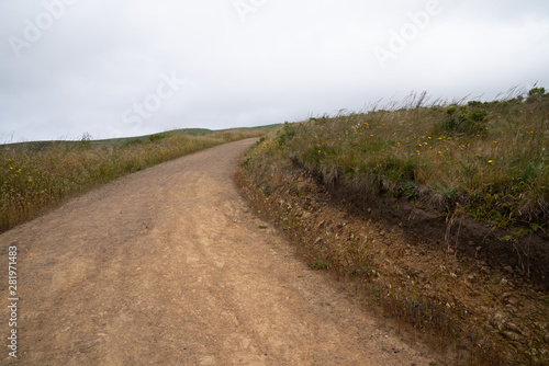 Winding dirt hiking trail curving to right, sense of unknown direction into horizon