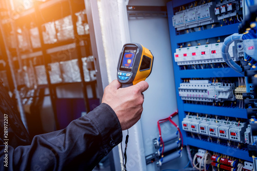 Technician use infrared thermal imaging camera to check temperature at fuse-box