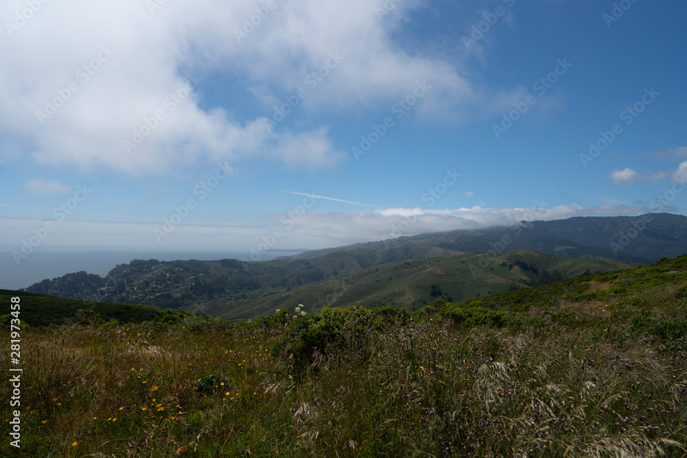 Hills and bushes in ocean side trail with clouds and nature Hills and bushes in ocean side trail with clouds and nature