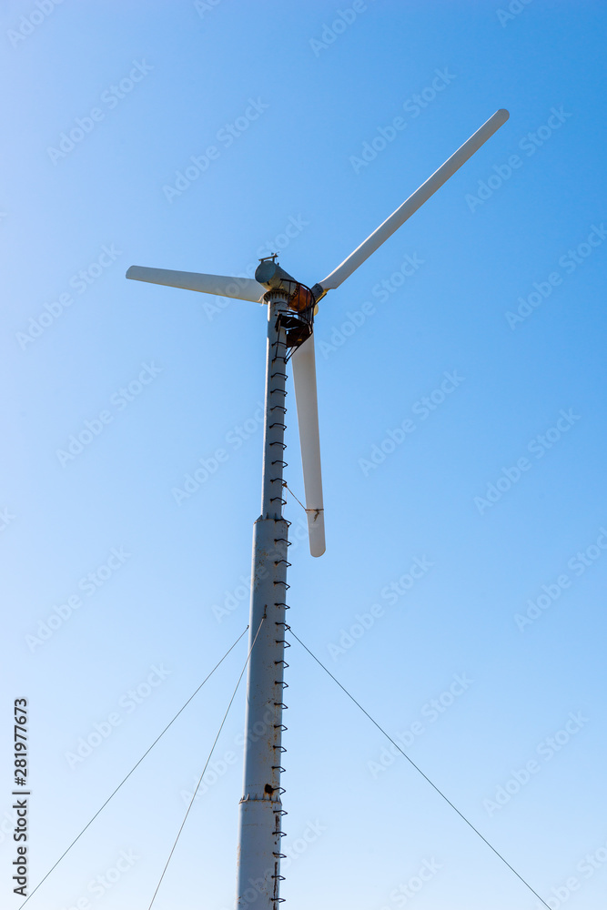 Windmill power generator against blue sky Windmill power generator against blue sky