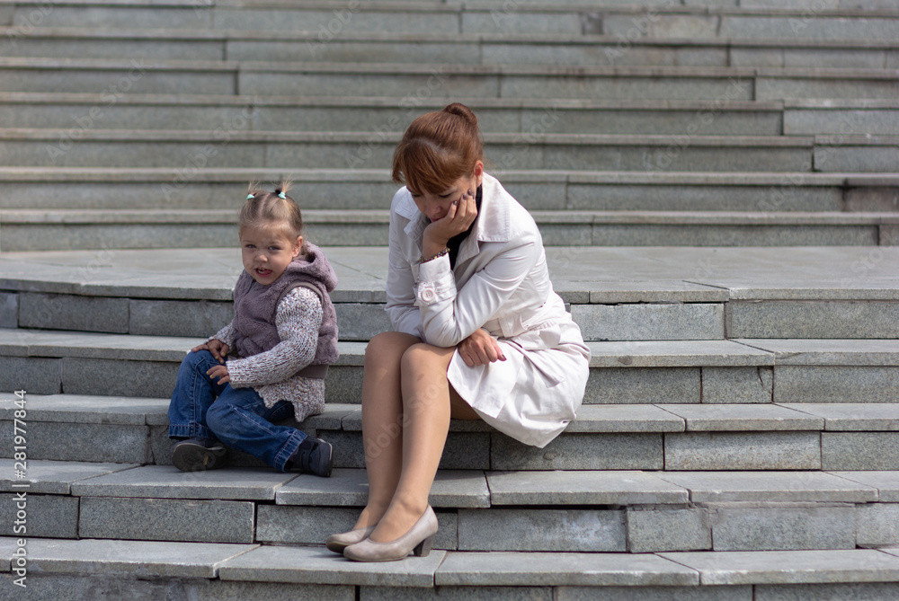 Child and mother sitting on stairs and waiting for somebody Child and mother sitting on stairs and waiting for somebody